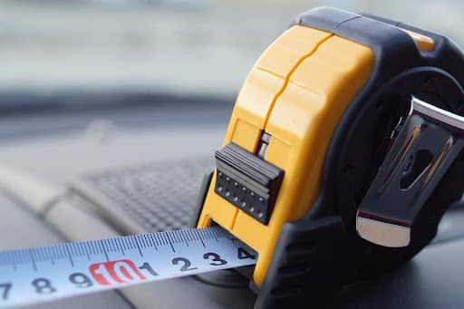 A yellow and black tape measure with a black numbers on a white background.