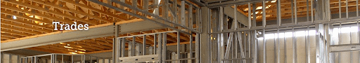 A screenshot of a website header with the title "trades" and imagery of an indoor construction site.